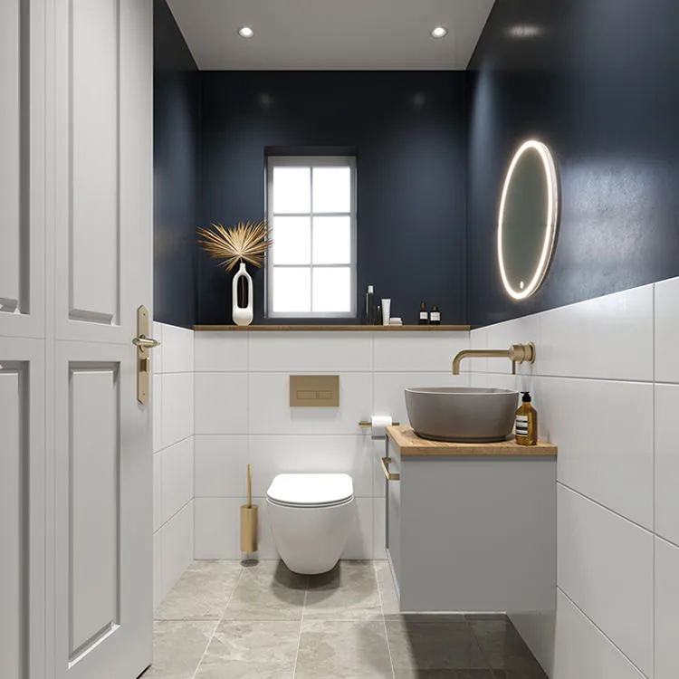 Digital image of a small bathroom, featuring granite floor tiles, white wall tiles and dark blue painted walls, a wall mounted toilet paired with brushed gold push plates, toilet roll holder and wall mounted toilet brush holder, integrated wooden shelf, wall mounted washbasin unit, countertop basin with wall mounted brush gold tap and a LED mirror