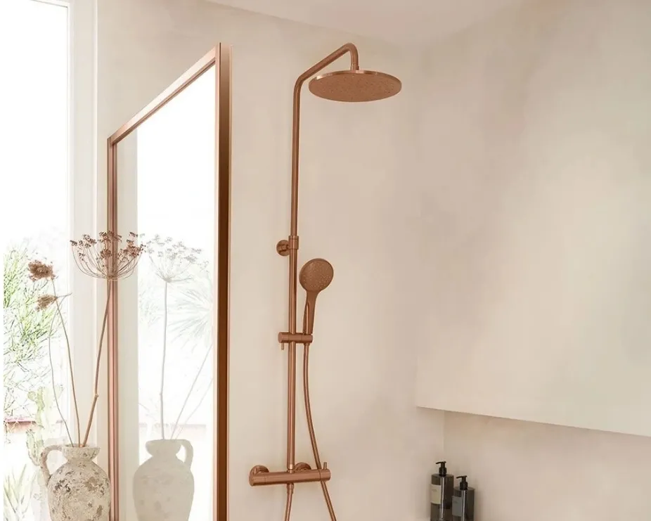 image of a brushed bronze multifunction shower set with head and handset in light bathroom