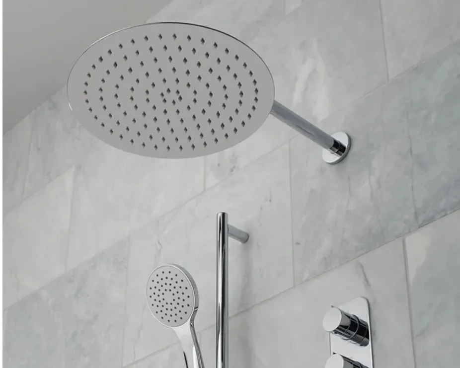 image of a chrome shower set with wall mounted shower head, riser rail kit and vave on white marble tiled walll