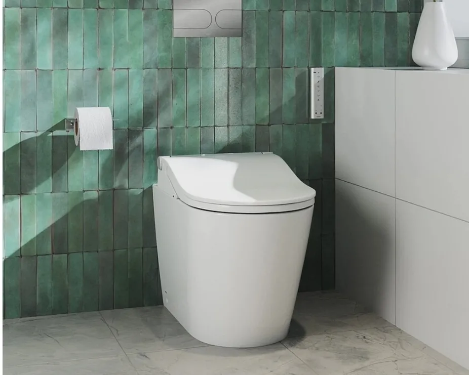 image of a TOTO Shower Toilet in a grey brick tiled bathroom space with chrome flush plate
