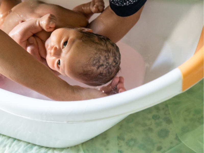 baby being bathed in a baby bath