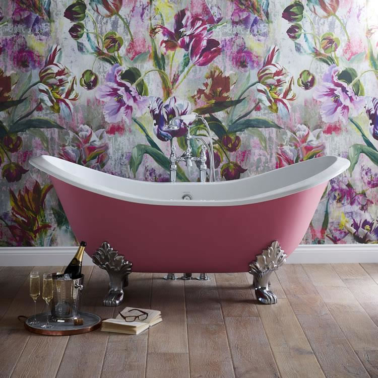 Lifestyle image of a floral themed bathroom, featuring a pink painted boat bath and floral wallpaper