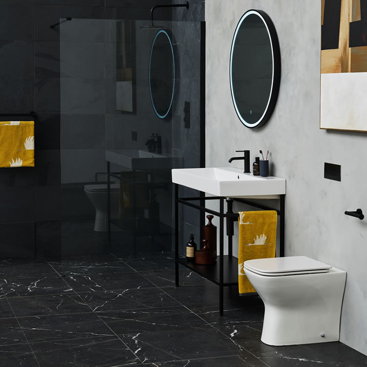 Lifestyle image of a black and white themed bathroom, featuring black marble floor tiles, white marble wall and black granite wall tiles, matt black washstand, white ceramics and matt black brassware