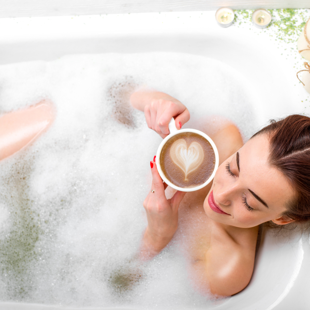 image of woman soaking in bath with cup of coffee