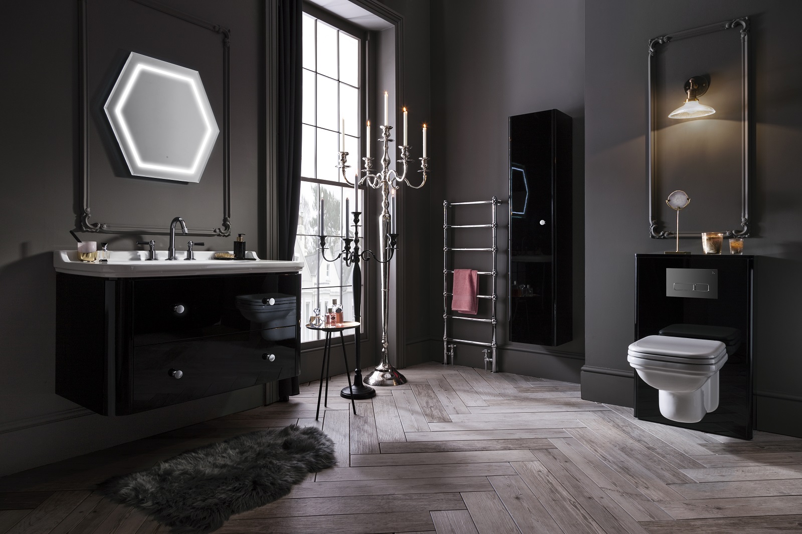 Lifestyle image of a black bathroom design, featuring a gloss black washbasin unit, a gloss black wall hung cabinet, a gloss black cistern housing and black painted walls