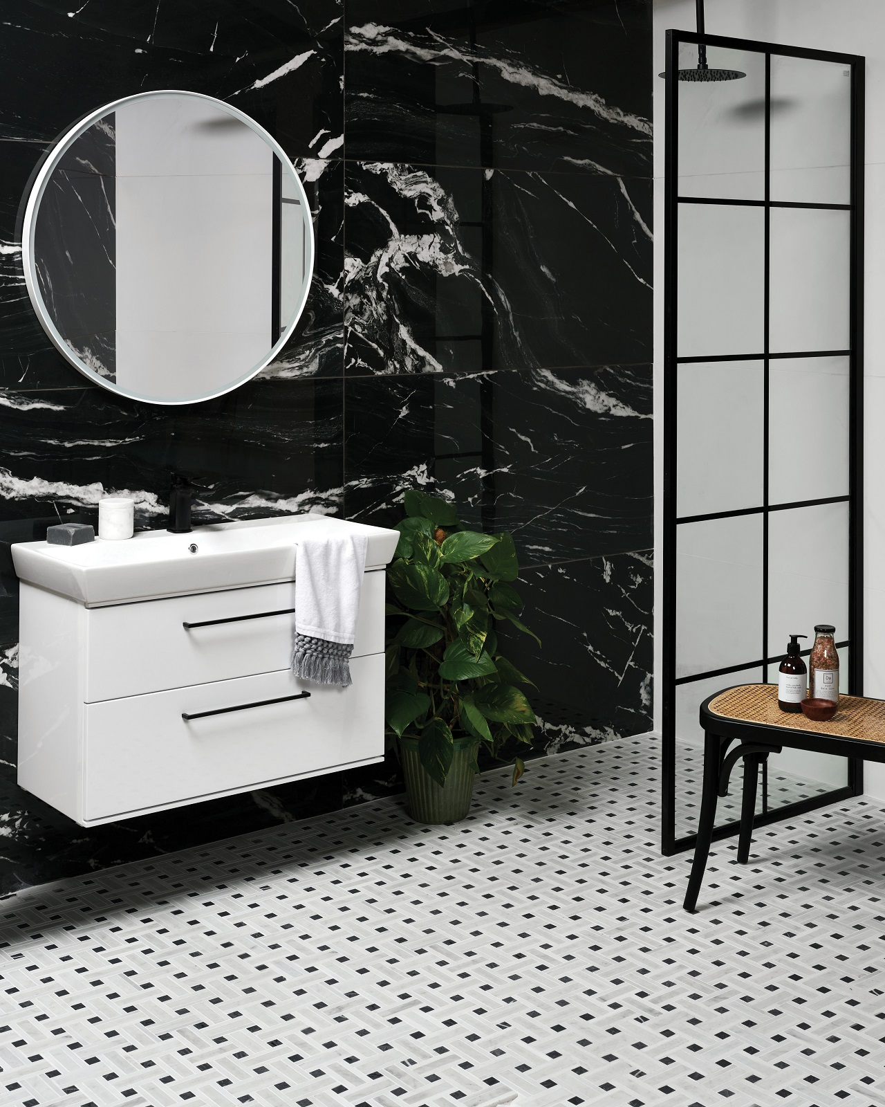 Lifestyle image of a bathroom featuring black marble wall tiles, black crittall framed shower enclosure and matt black brassware
