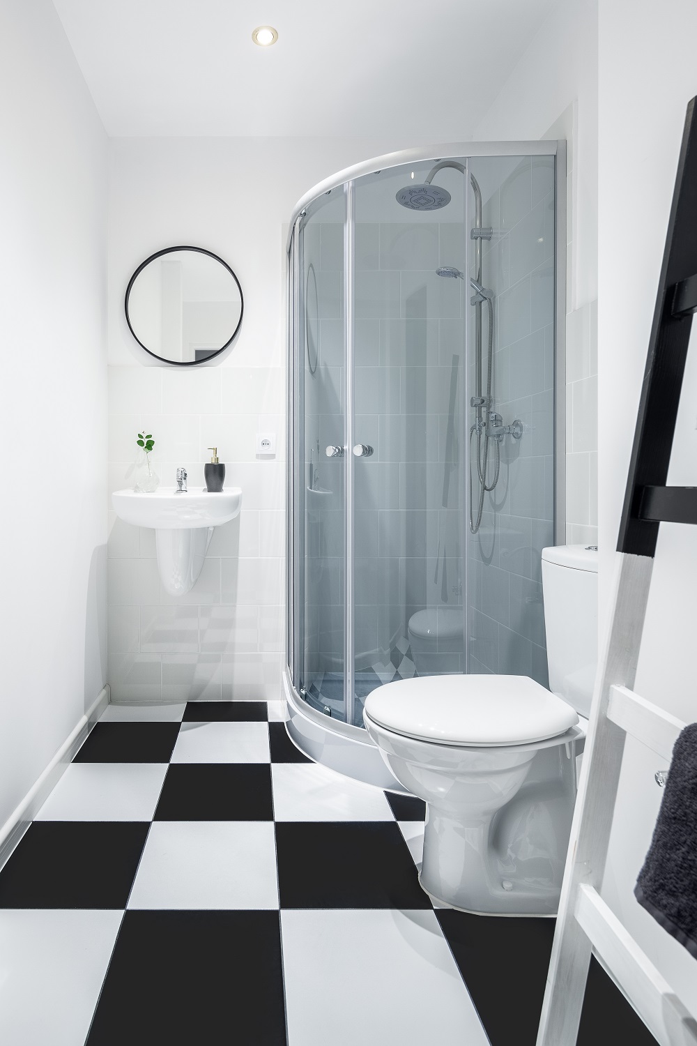 Digital lifestyle image of a small bathroom with black and white chequerboard floor tiles