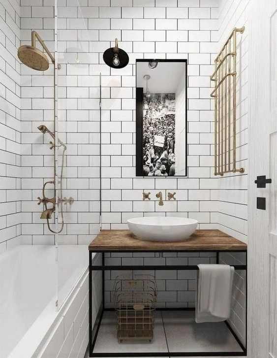 Lifestyle image of a white and brown bathroom design, featuring white floor and wall tiles, copper brassware and a wooden countertop with a white countertop basin