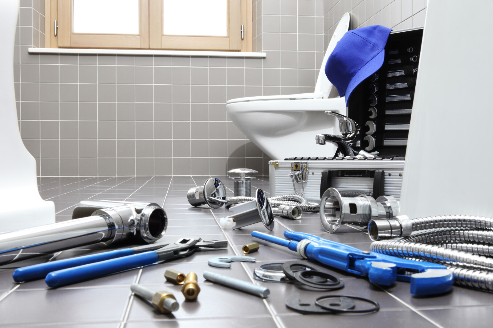 Close up image of the various tools and parts needed to install a bathroom basin and taps