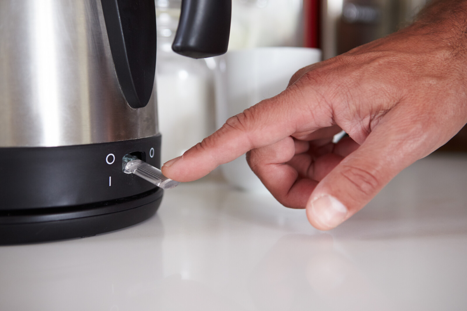 Close up image of a man turning on his kettle
