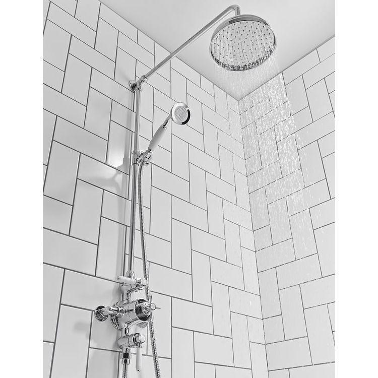 image of tavistock cheltenham overhead shower system with rainfall function on in chrome fitted in white patterned brick tile bathroom space