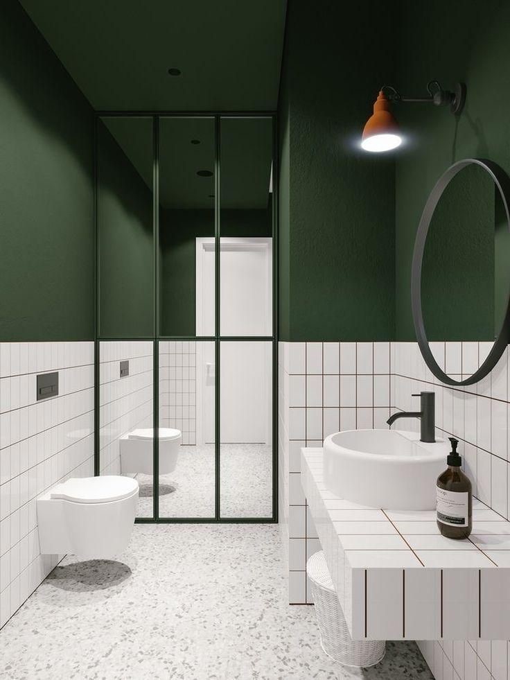 Lifestyle image of a green and white bathroom, with a white terrazzo floor, white wall tiles, green brittall framed shower screen and emerald green painted walls and ceiling