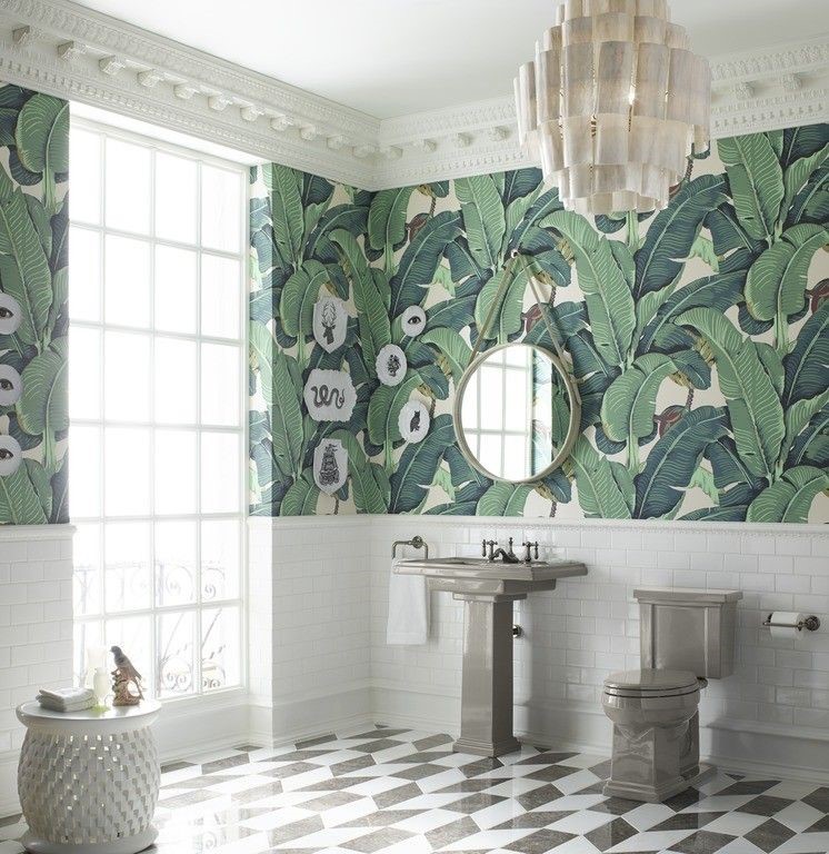 Lifestyle image of green and white bathroom design, featuring avacado close coupled toilet and pedestal basin, white tiled bathroom walls and green leafy wall paper