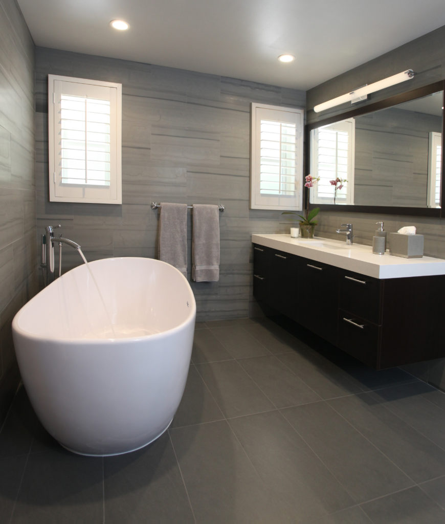Lifestyle image of a grey bathroom design, featuring grey floor tiles and striped grey wall tiles