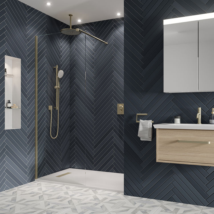 Product Lifestyle image of Crosswater Gallery 10 Brushed Brass Wetroom Screen housing an enclosure with blue grey chevron style tiles