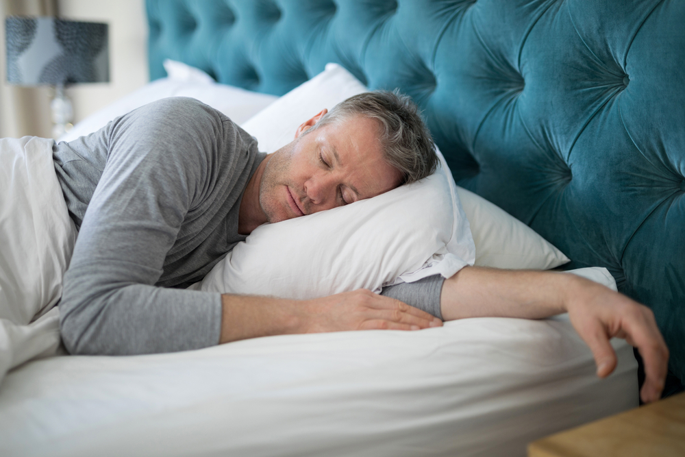 Lifestyle image of a man sleeping in a bed