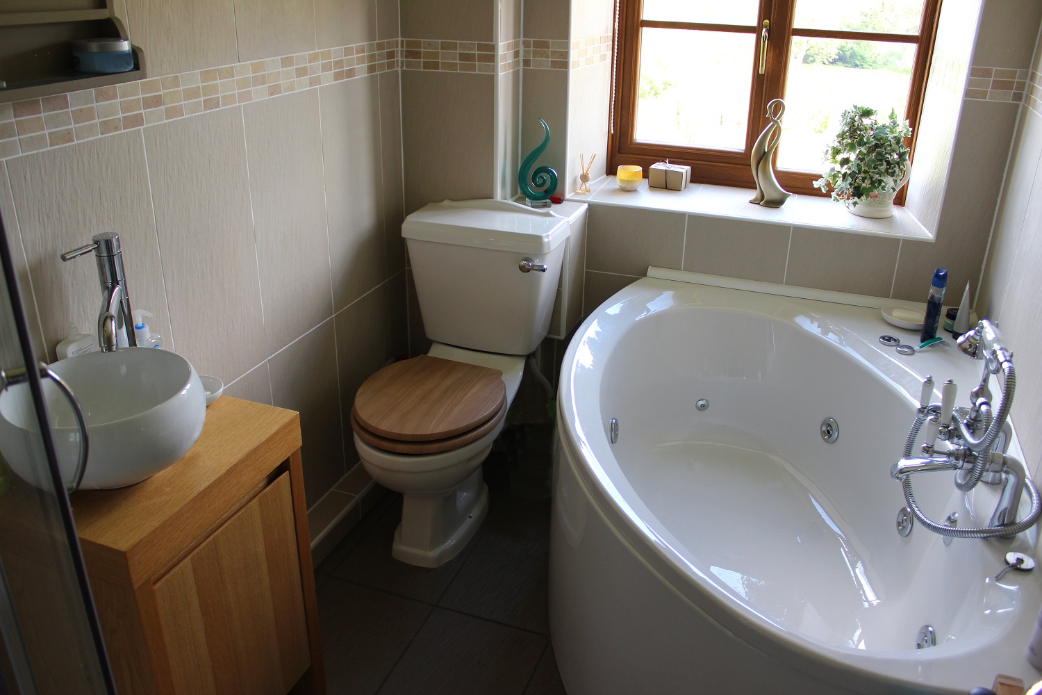 Lifestyle image of a small bathroom with corner bath and toilet