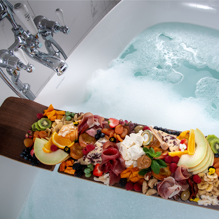 High angle image of a charcuterie board stretched across a bubble bath