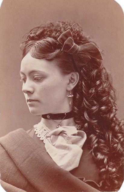 Sepia tone image of a Victorian woman with her hair platted and wringleted