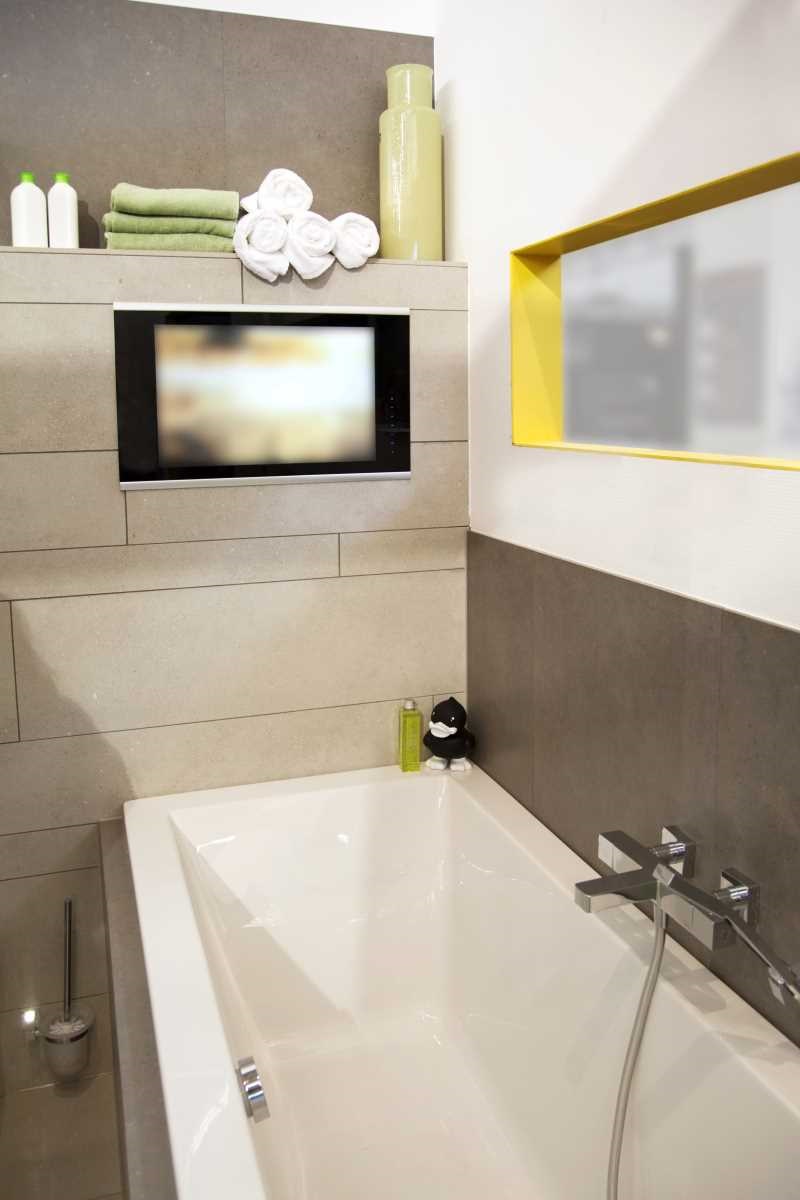 Lifestyle image of a waterproof television installed in the wall above a bath