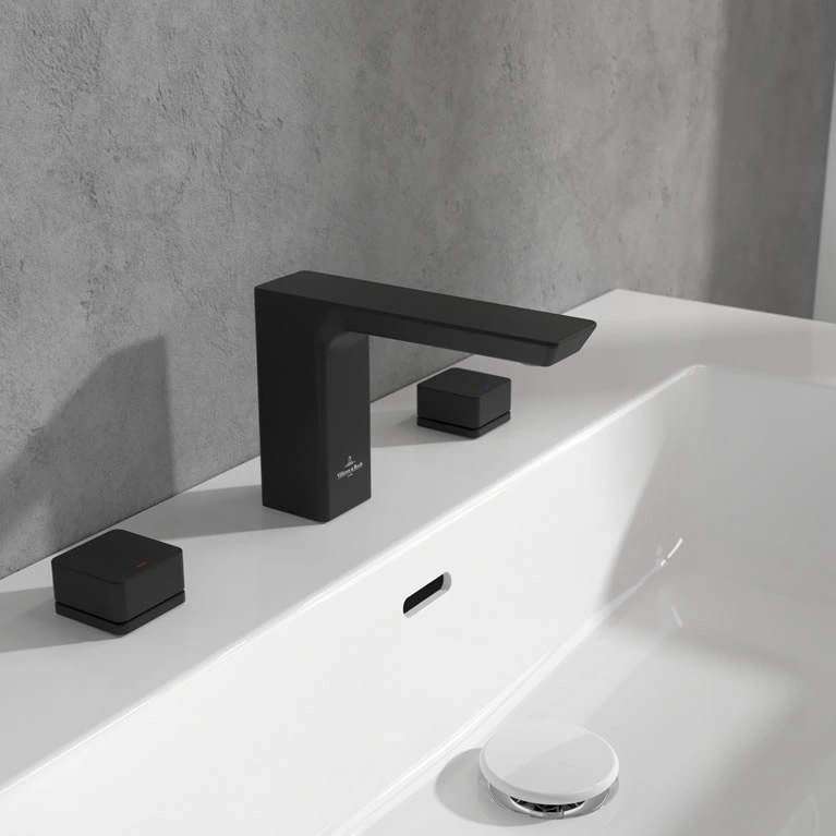close up of a basin with 3 tap holes and separate spout and hot and cold controls in matt black