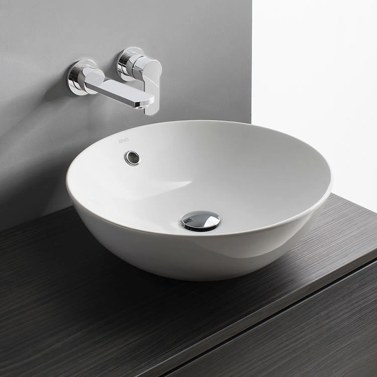 image of a ceramic vitreous china countertop basin bowl on dark wood vanity unit with grey wall