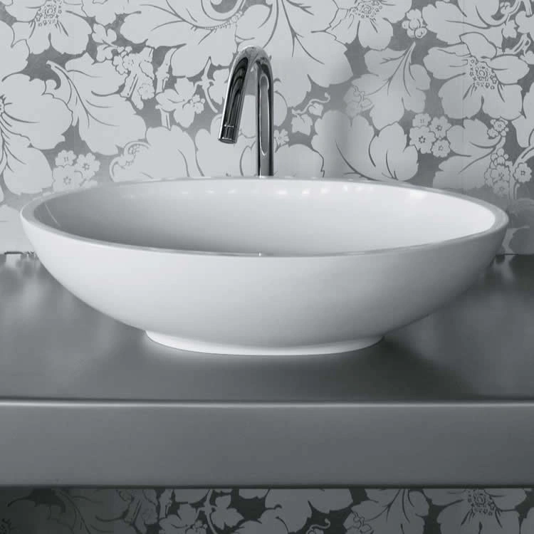 image of a solid surface cian countertop basin on grey metal surface in front of floral patterned wall