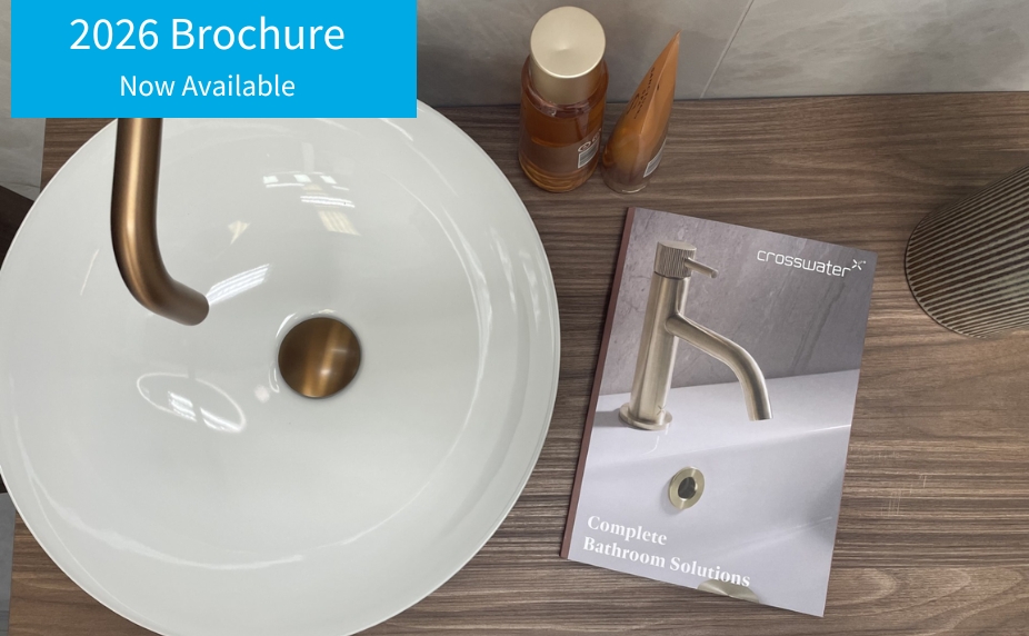 image of crosswater 2026 brochure on wooden vanity unit next to basin, bottles and plant
