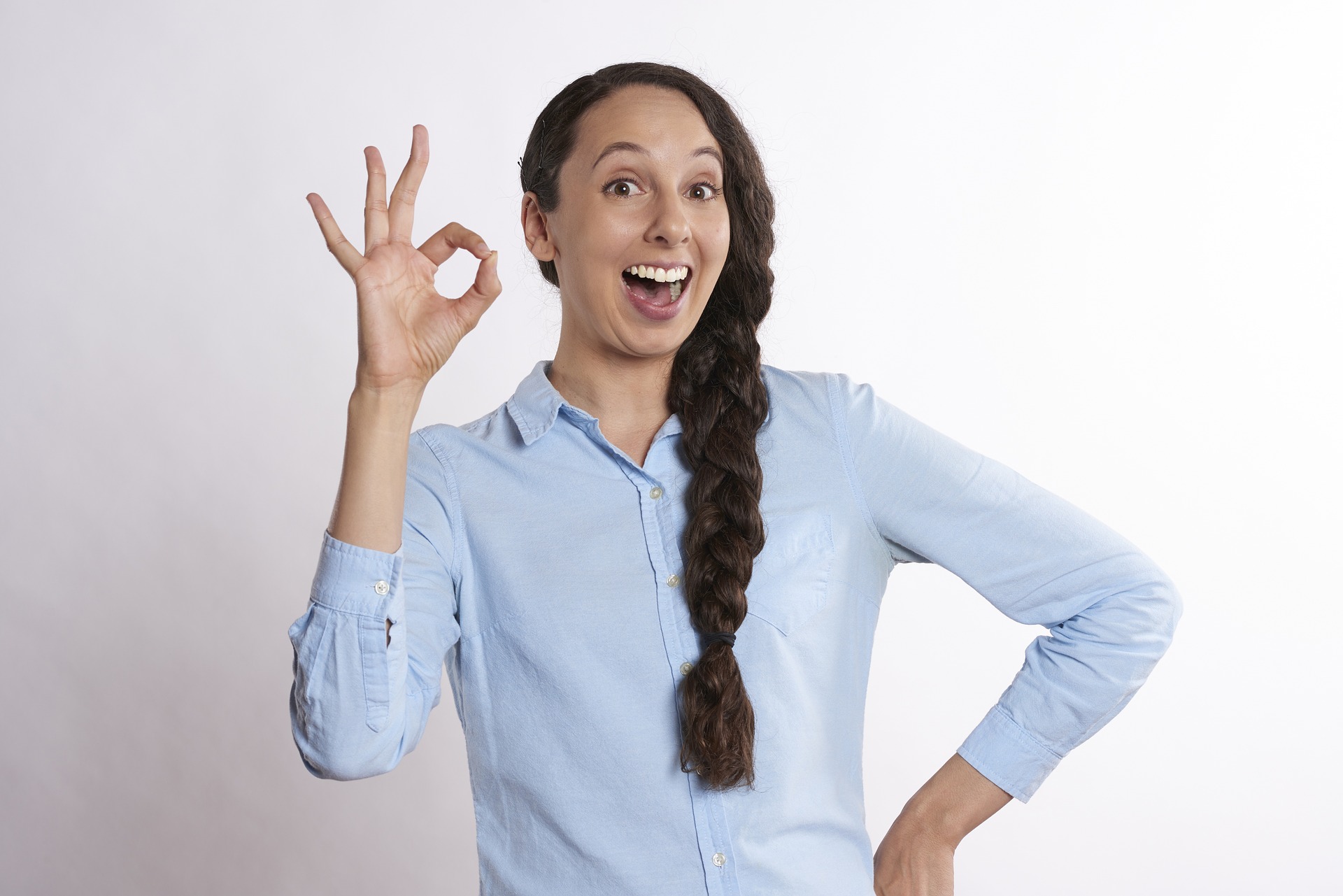 Image of a woman smiling and making an OK sign with her fingers