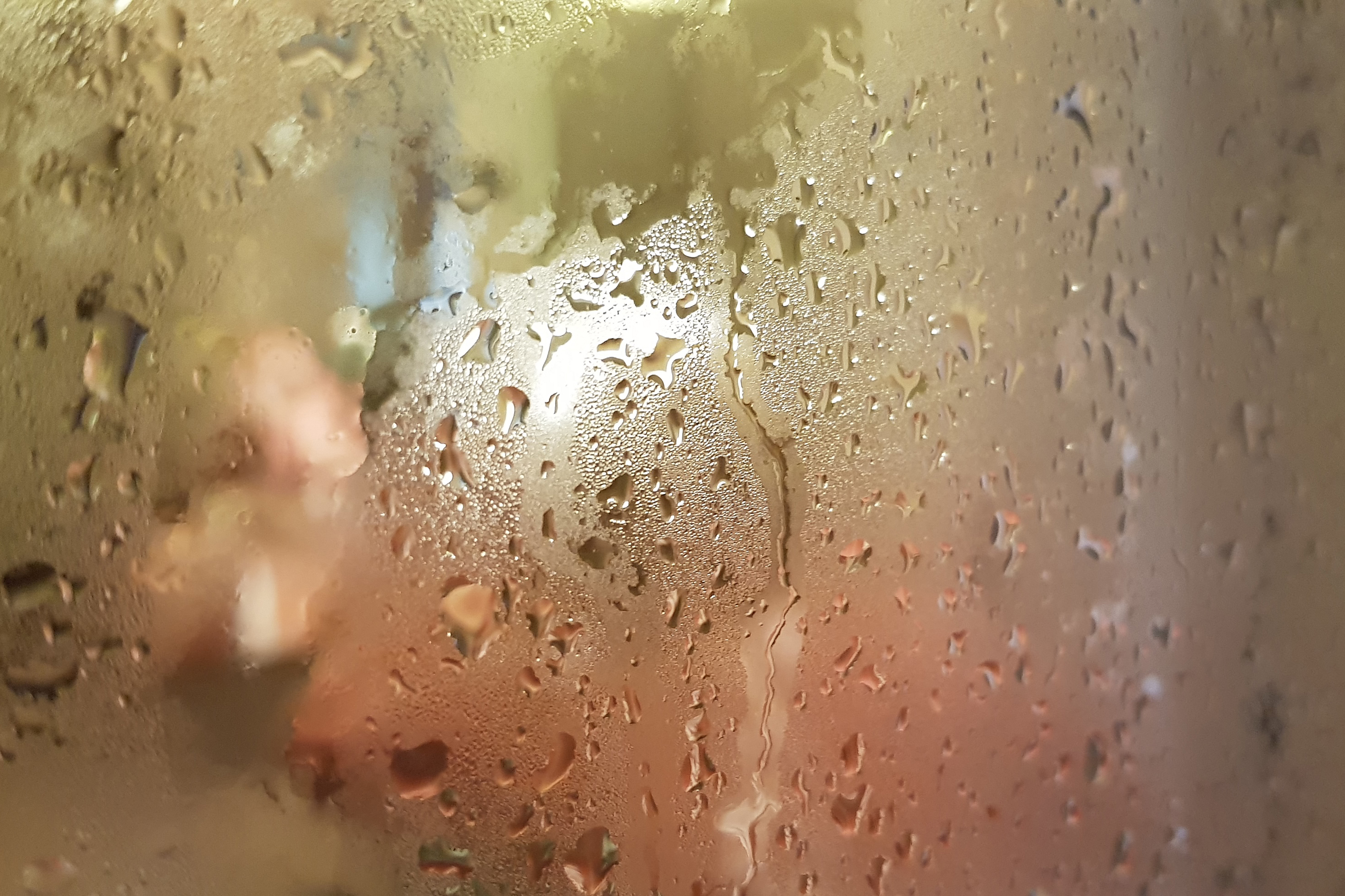 Close up image of a steamed up shower bath screen