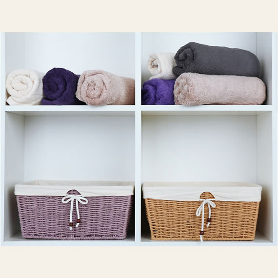 Lifestyle image of towels and wicker baskets being stored on integrated shelves