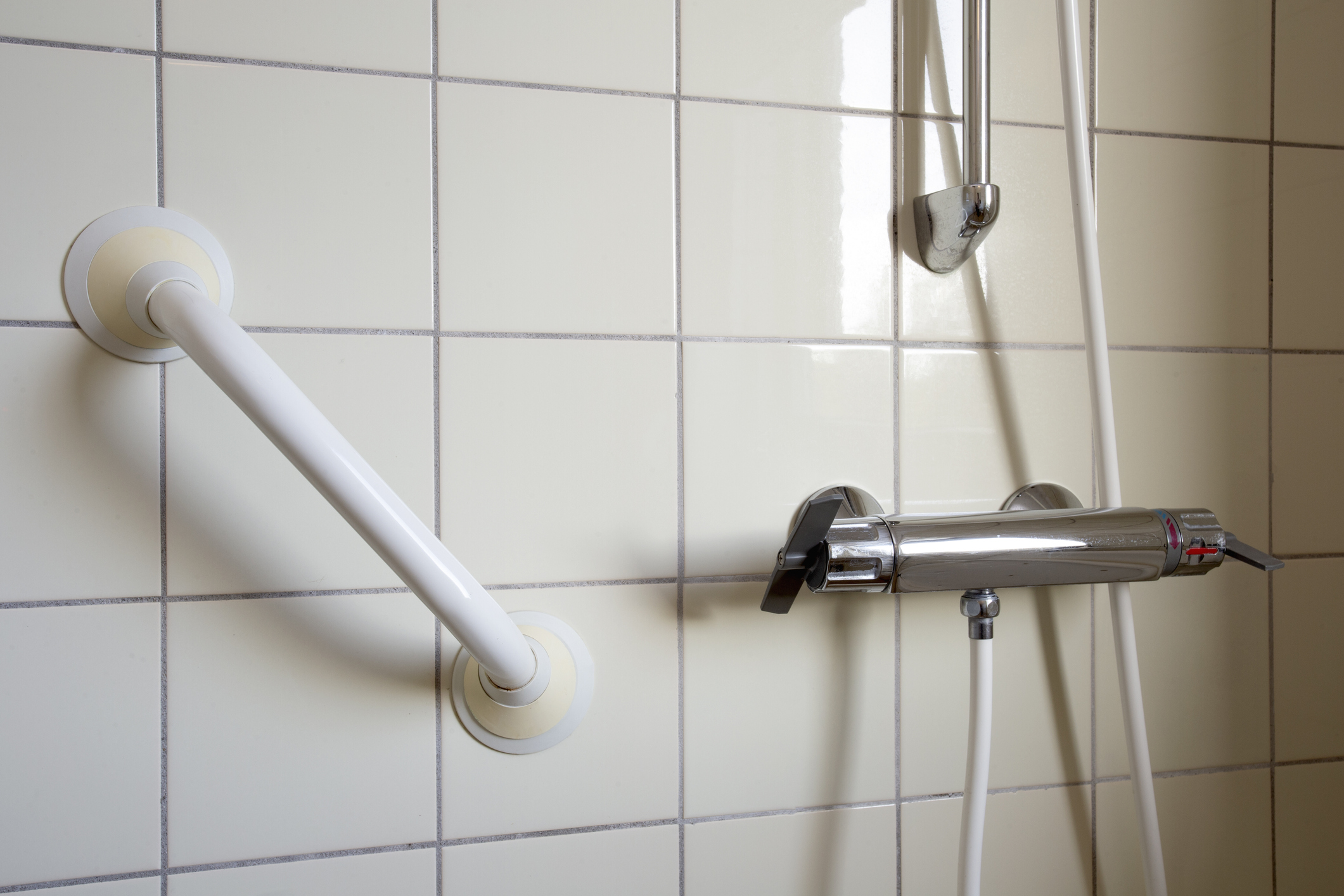 Lifestyle image of grab rail attached to the wall of a shower enclosure