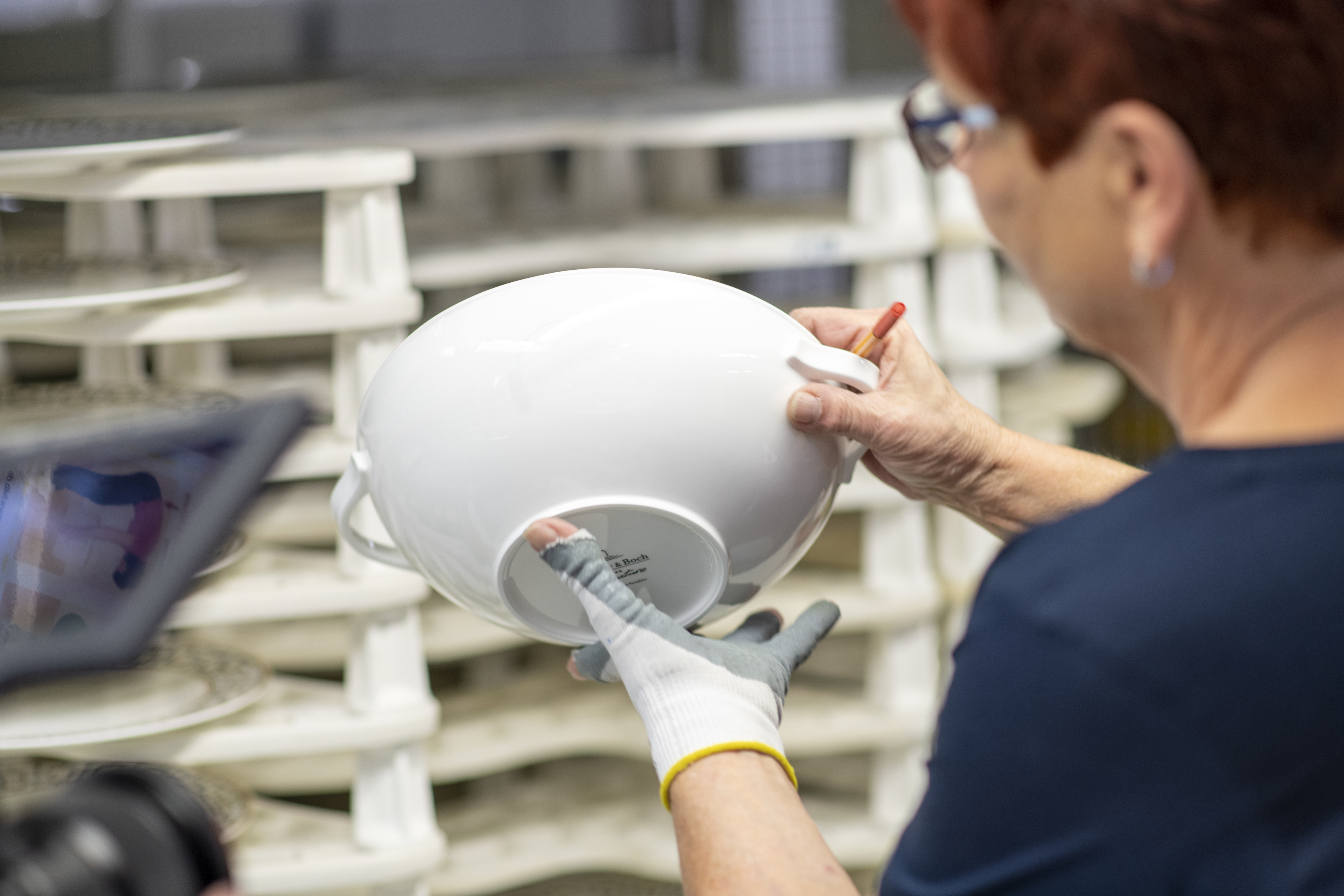 image of a Villeroy and Boch worker looking at a ceramic basin in their factory in Germany