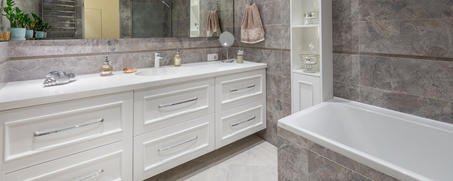 image of a run of fitted furniture in gloss white with chrome handles in grey marble bathroom