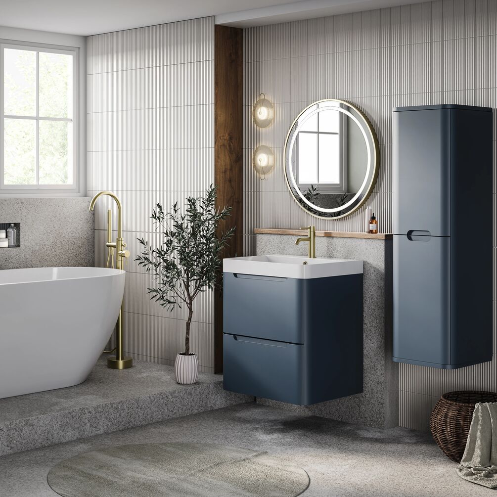 A bathroom with blue vanity unit and cabinet, and round LED mirror