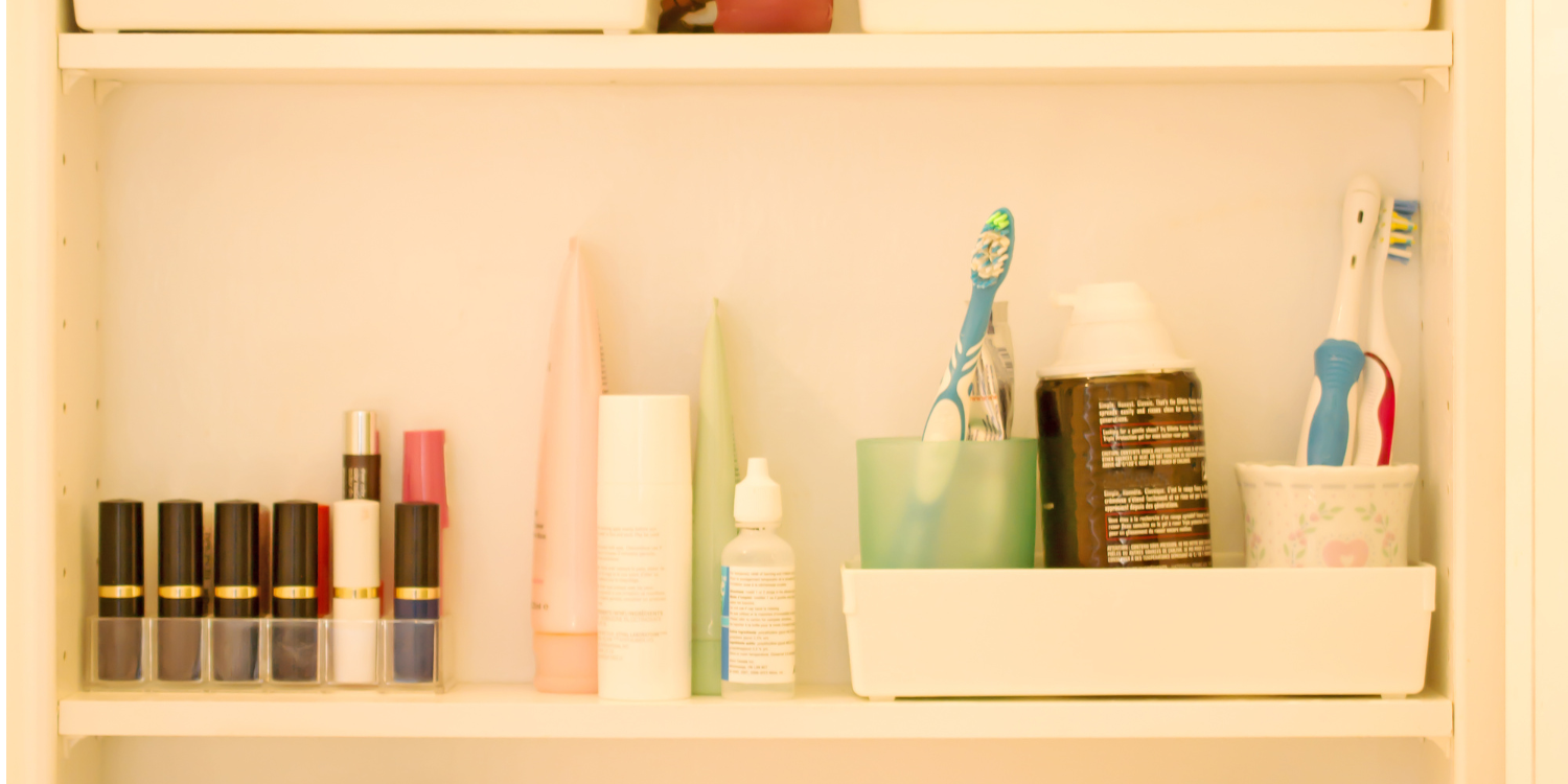 photo of the inside of a bathroom cabinet with makeup and beauty products stored neatly away