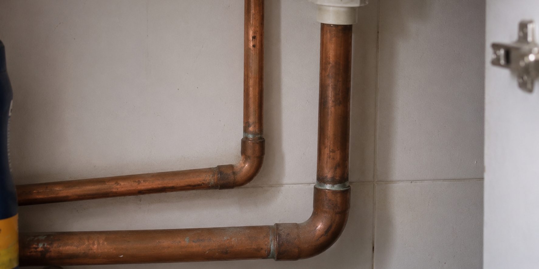 copper pipes beneath a vanity unit