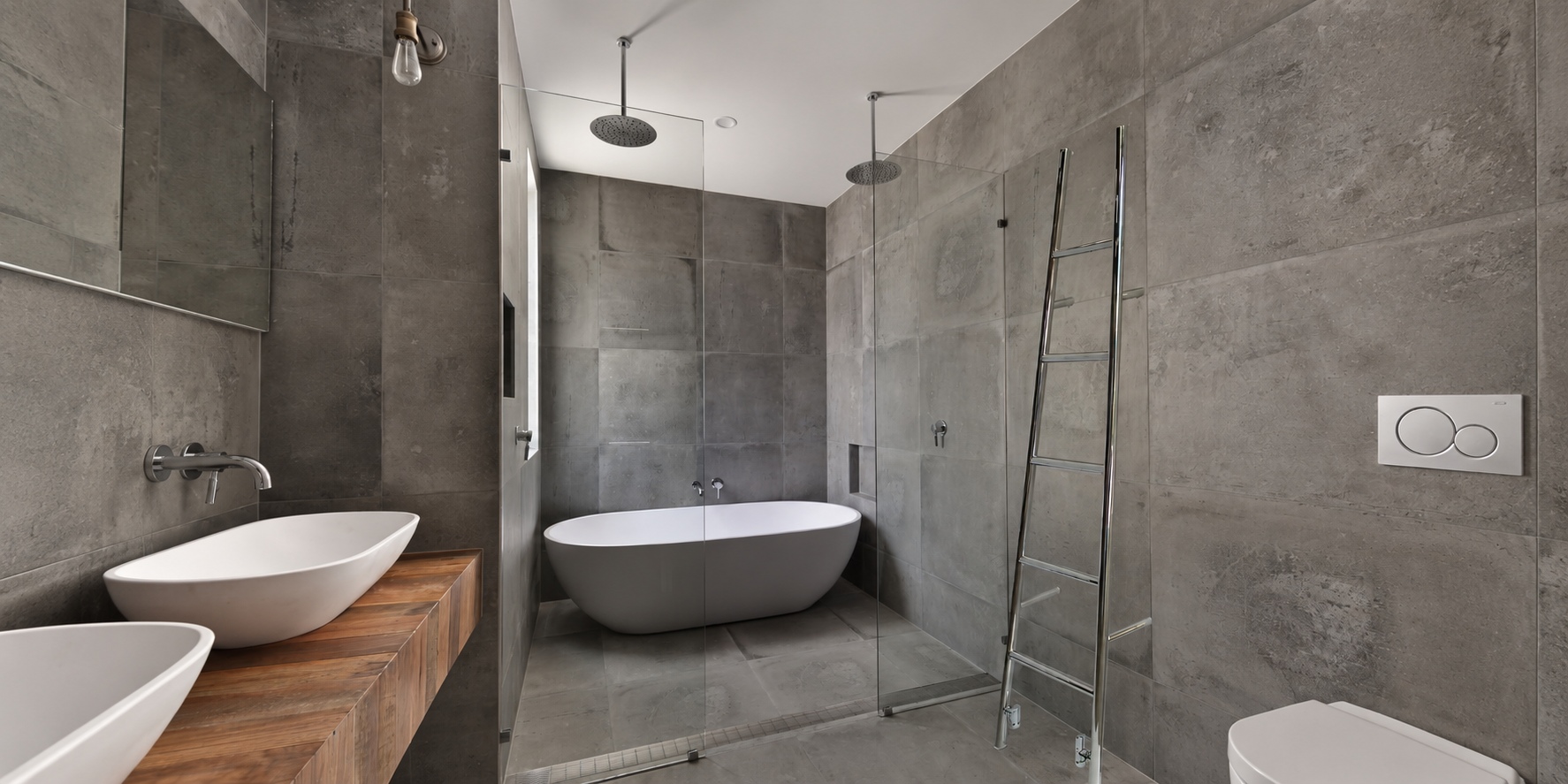 Lifestyle image of The Sussex Range by JIS Rye 1800mm x 520mm Polished Stainless Steel Heated Leaning Towel Rail in a concrete wet room