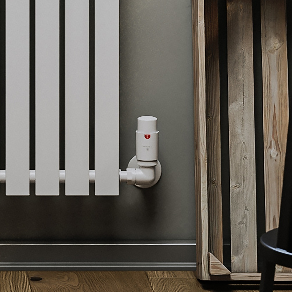 Product Lifestyle image of the Terma Vario Vision Matt White Right Sided 3 Axis Radiator Valve attached to the side of a modern radiator