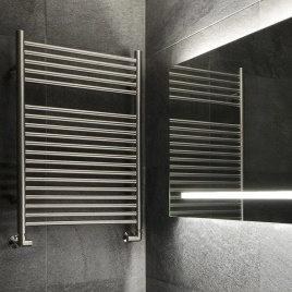 image of the sussex range by jis coombe electric towel rail on grey bathroom wall next to illuminated backlit mirror