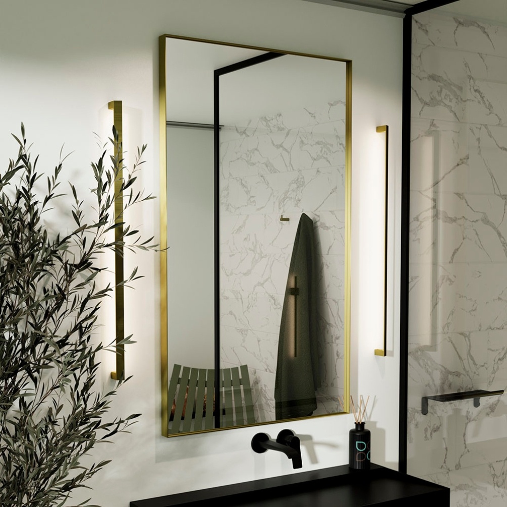 Lifestyle image of the Origins Living Newington 600mm x 800mm Brushed Brass Rectangular Mirror handing on a white wall next NWG-001068-BB