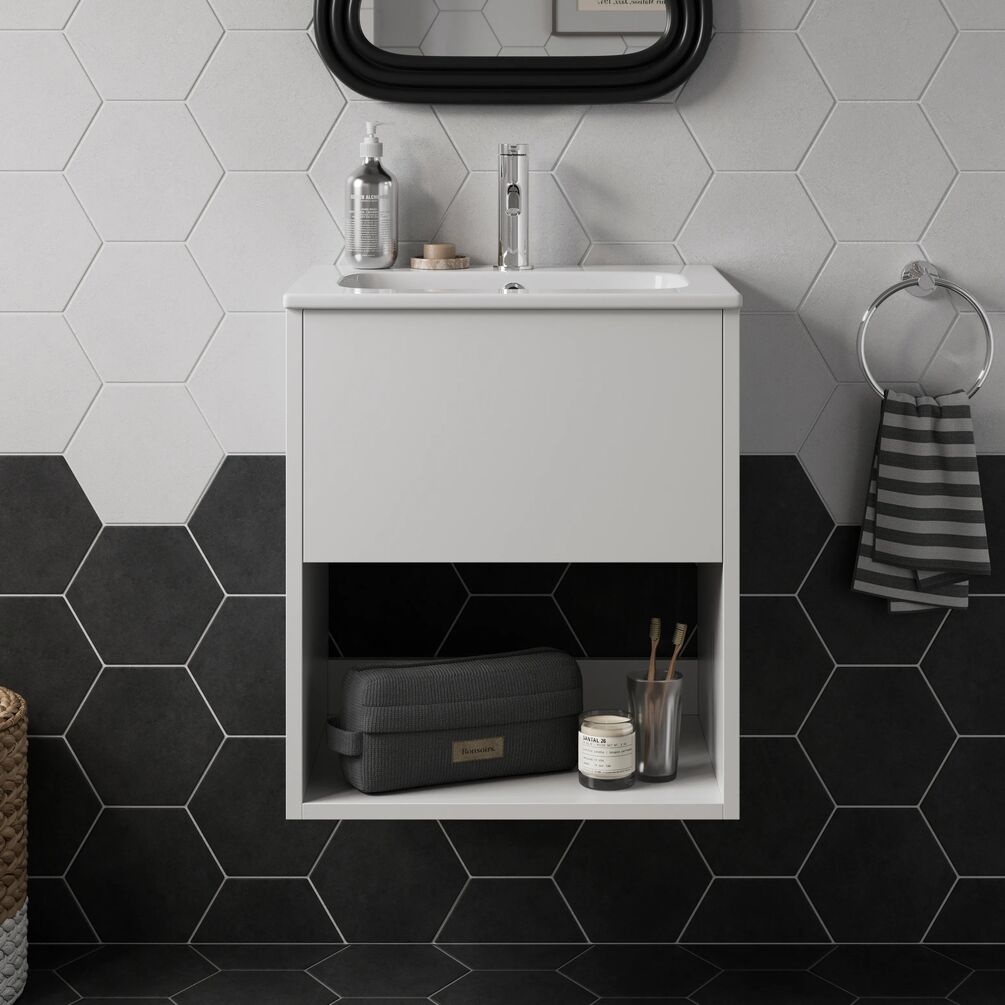 Lifestyle image of the Britton Hackney Glossy White 500mm Wall Hung Vanity Unit & Basin installed in a black and white bathroom with items on the shelf