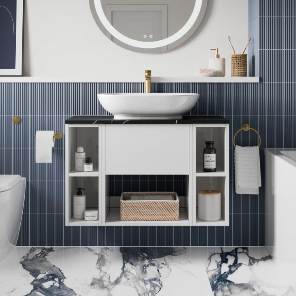 Lifestyle image of the Britton Hackney Glossy White 900mm Wall Hung Vanity Unit with Carrara Worktop & Two Shelf Units with countertop basin, installed on a blue tiled bathroom wall next to toilet and bathtub