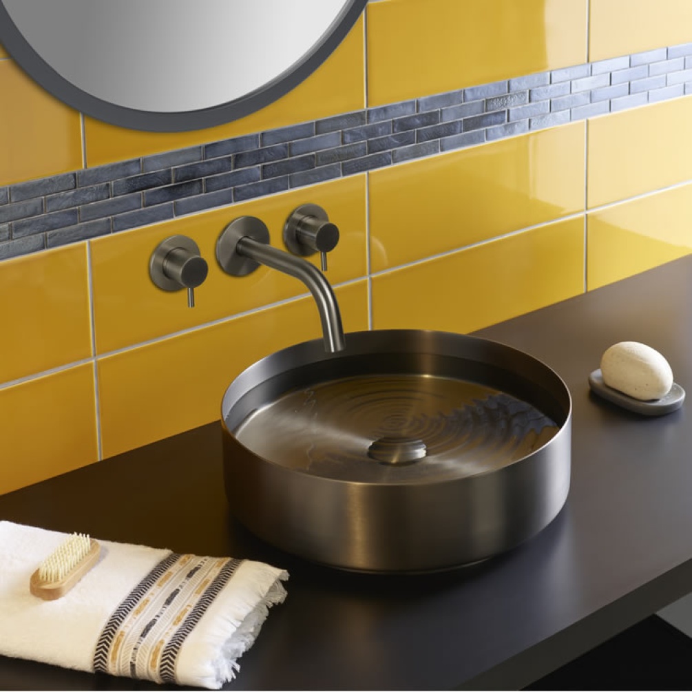 Product Lifestyle image of the JTP Vos Brushed Black Stainless Steel Round Countertop Basin paired with a wall mounted basin mixer