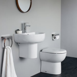image of a toilet and basin set matching from same range. It includes a back to wall toilet in a modern design and a d shaped semi-pedestal basin with chrome brassware and a round mirror hanging above on the wall