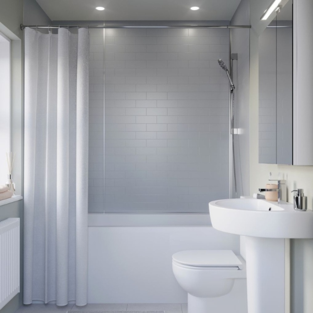 Lifestyle image of the Showerwall Compact Silver Grey 2440mm x 1220mm Tile Effect Wall Panel - SWCT02 installed behind a straight edged bathtub with riser rail shower kit