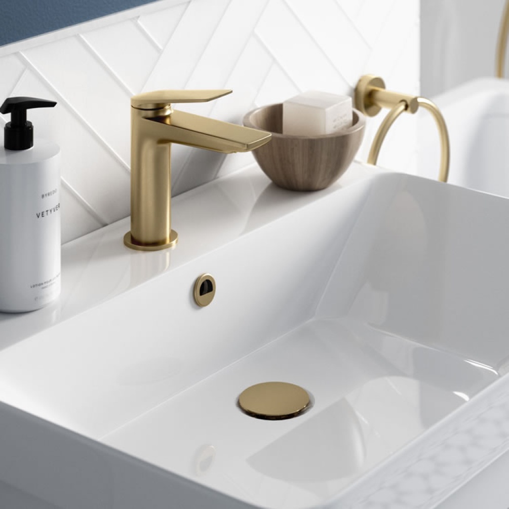 Photo of the Hoxton Overflow Cover in Brushed Brass with white tiles