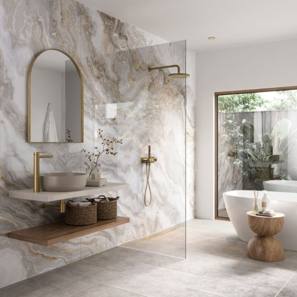 Lifestyle image of the Showerwall Acrylic Onyx Smoke 2400mm x 896mm Wall Panel - SCA71 installed in a complete wetroom environment with basin, freestanding bathtub and concealed shower, with a window in the background