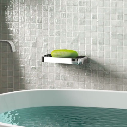 Lifestyle image of Origins Living Gedy Outline Shower Basket chrome mounted on grey-white tiled wall.