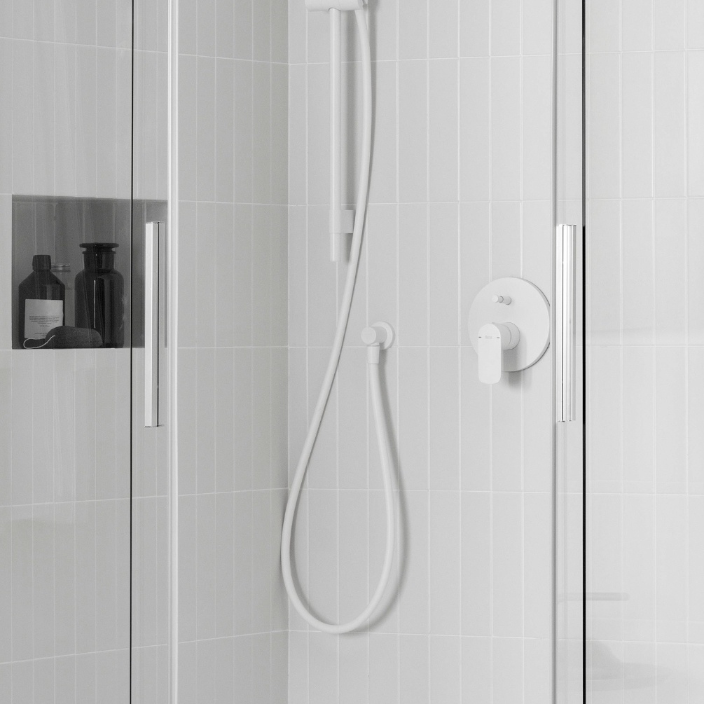 Lifestyle image of the Roca Flex Matt White 1500mm Anti-Twist Shower Hose installed in a shower cubicle